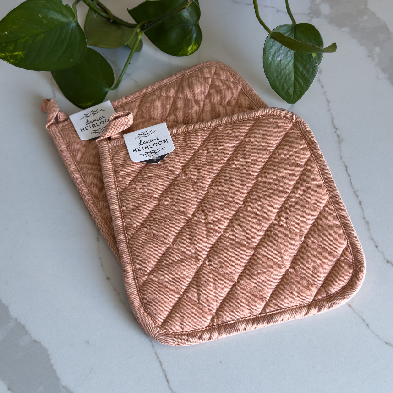 Two quilted cotton potholders in "nectar" pink colour