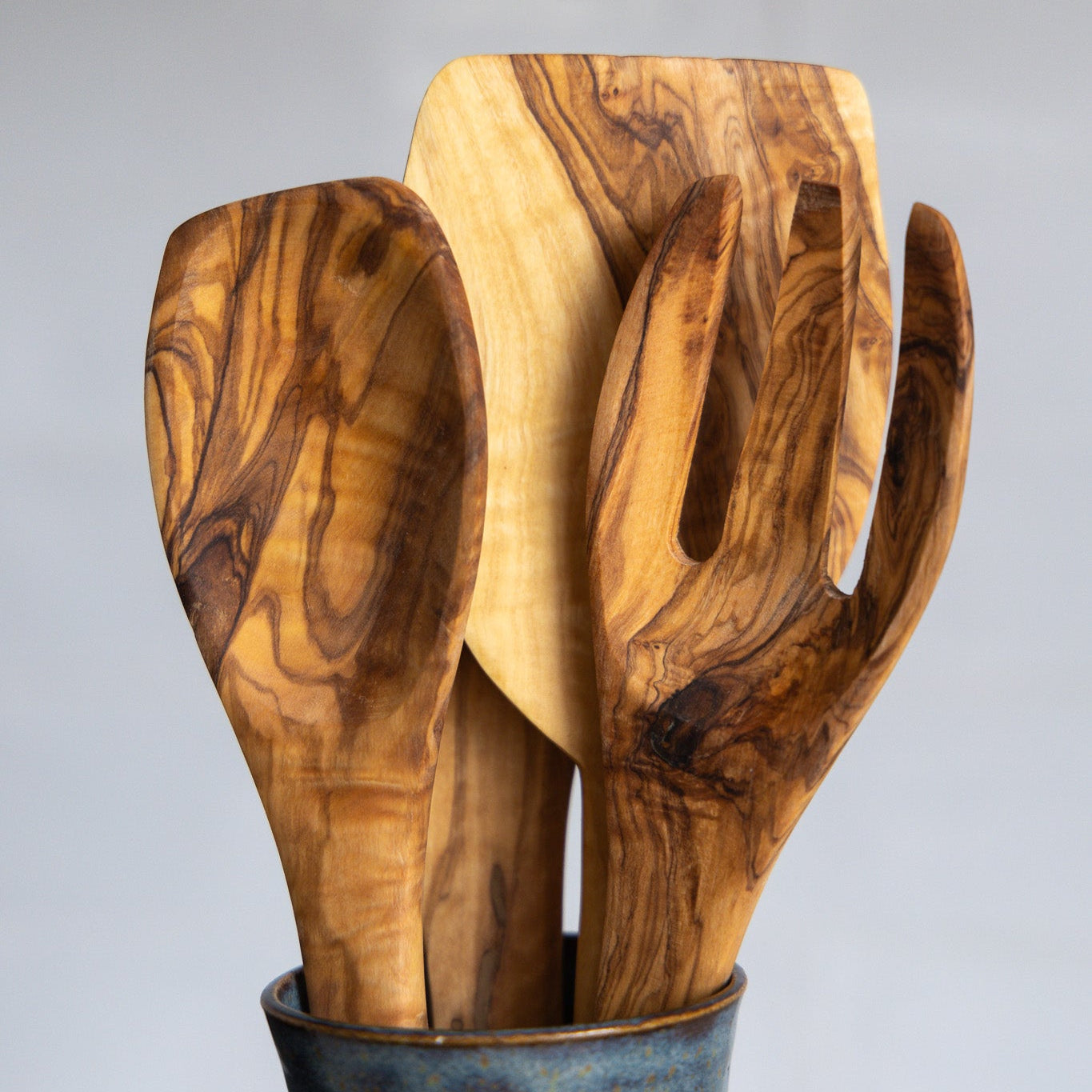 A close up of natural olive wood utensils showing detail