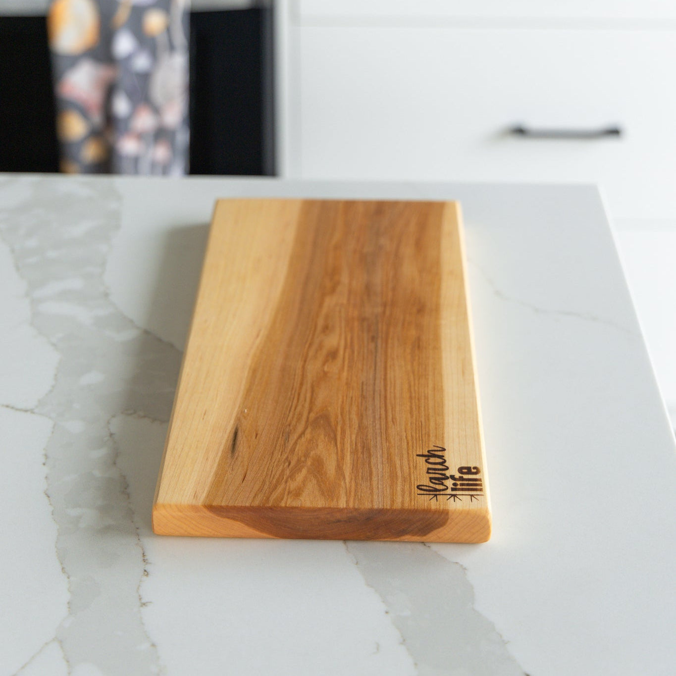 Wooden cutting board on a kitchen counter with a blurred background