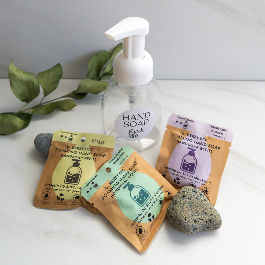 Three different scented eco-friendly foaming hand soap packages on a counter with refillable hand pump