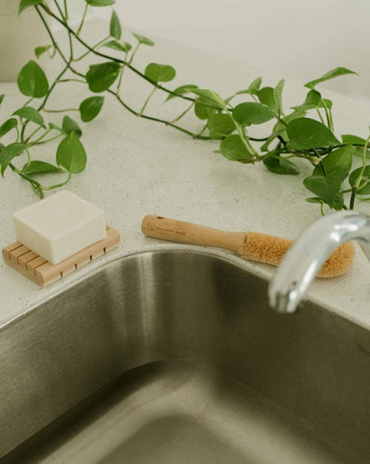 A bamboo brush sitting next to a sink