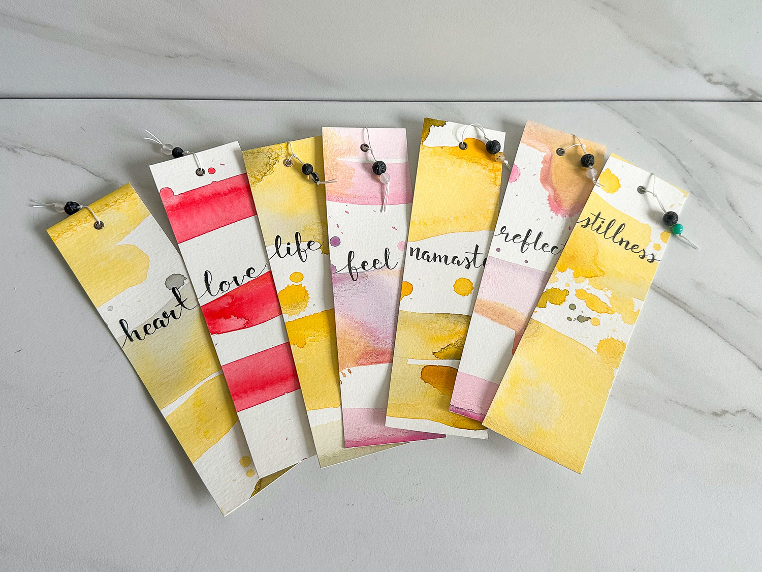 A variety of yoga-themed handmade watercolour bookmarks