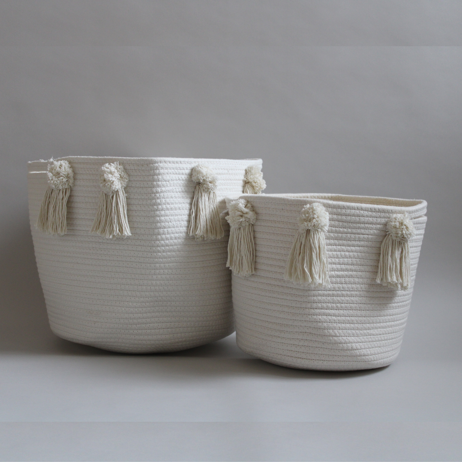 Two handmade cotton baskets with pom-poms and tassles