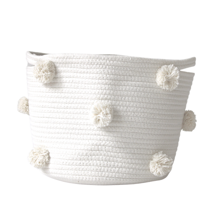 A medium handmade natural cotton basket with white pom-poms