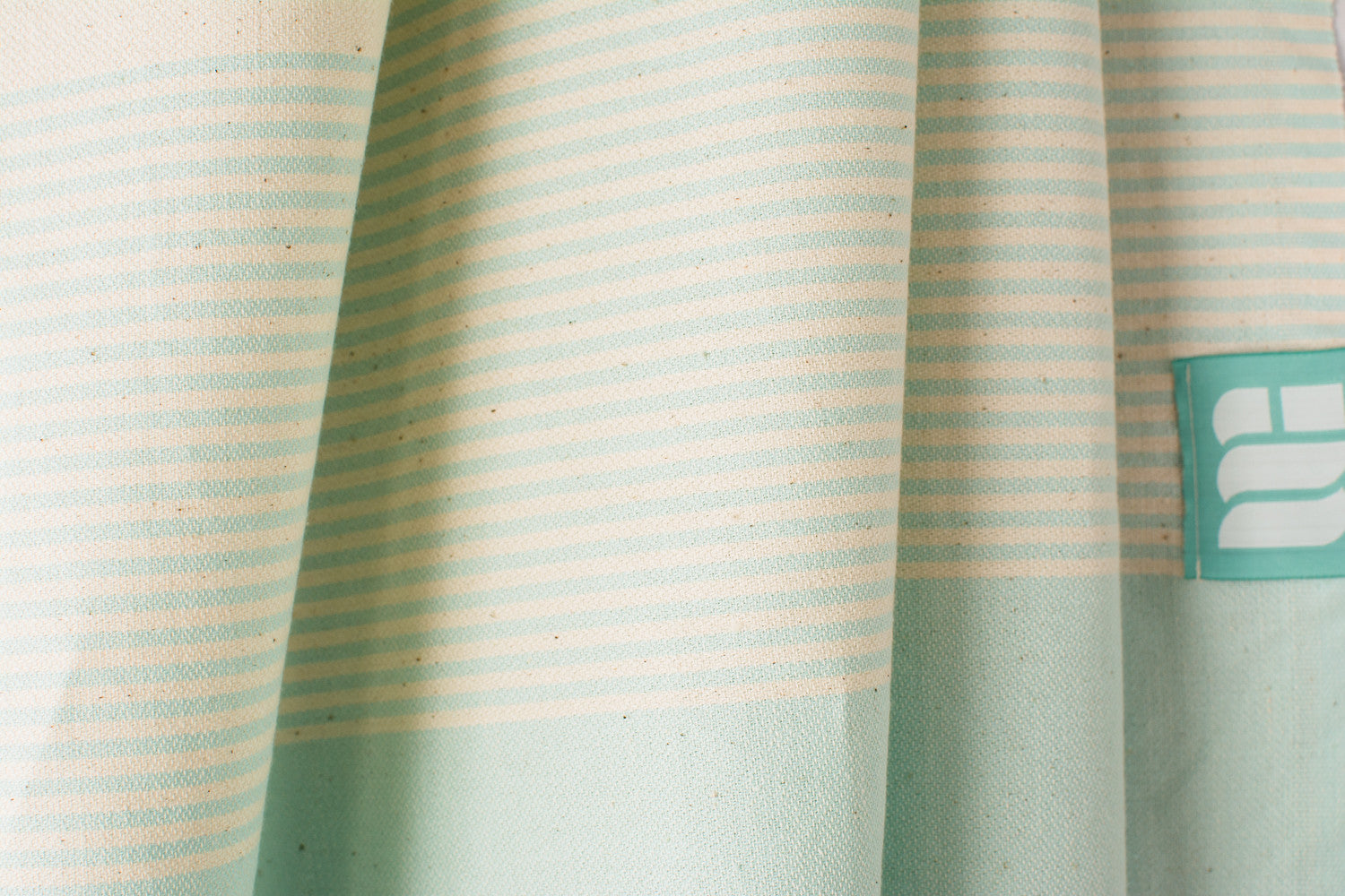 A close up of an aqua lightweight Turkish bath towel showing texture