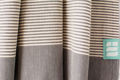 A close up of a charcoal grey lightweight Turkish bath towel showing texture