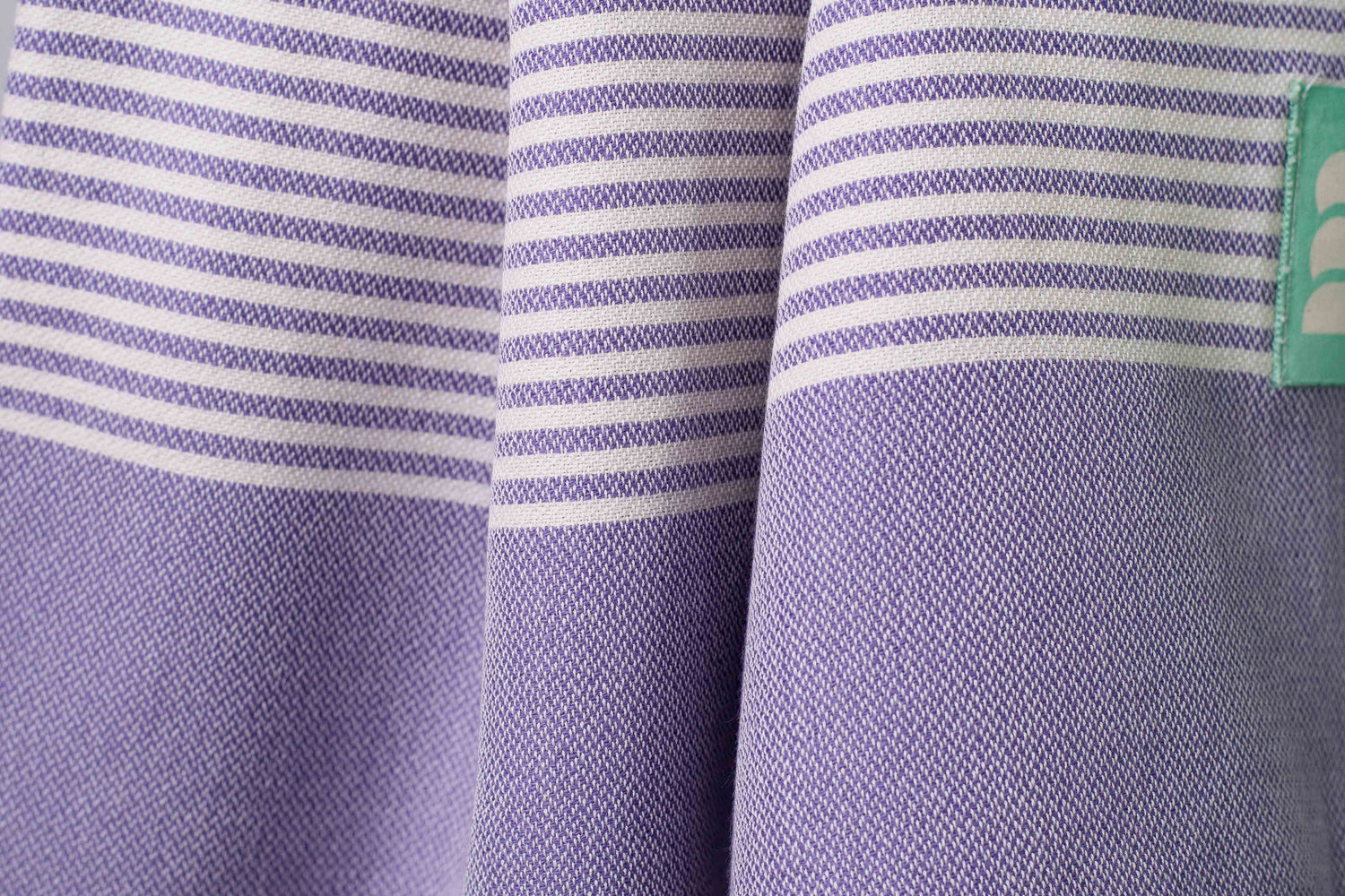 A close up of a purple lightweight Turkish bath towel showing texture