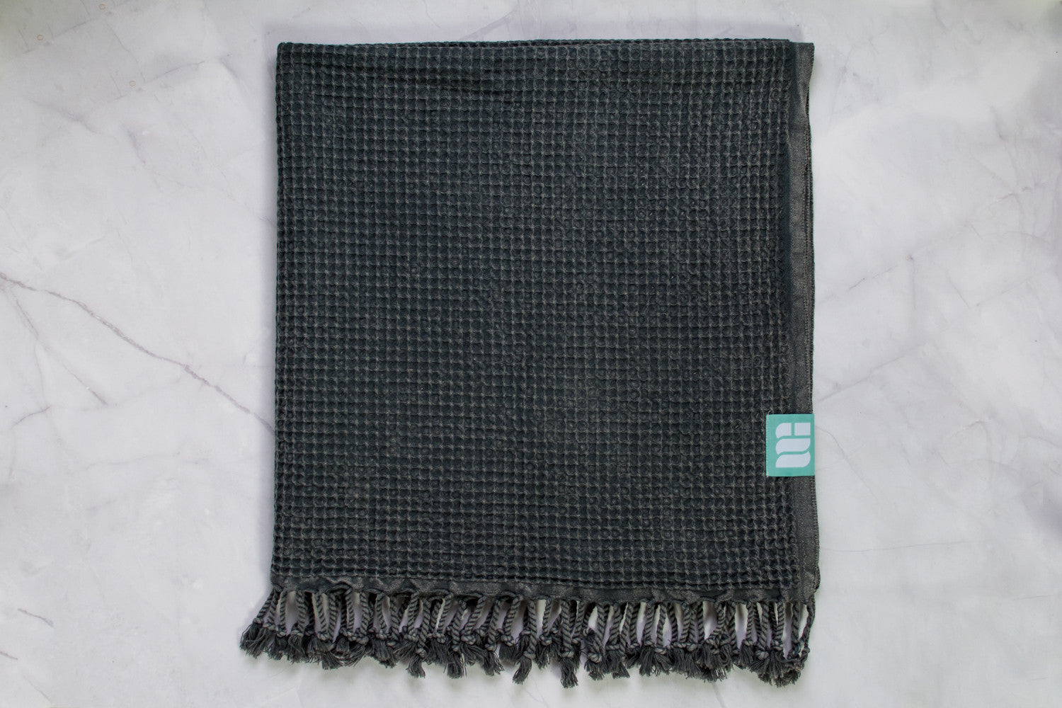 A waffle texture natural cotton Turkish bath towel in dark grey