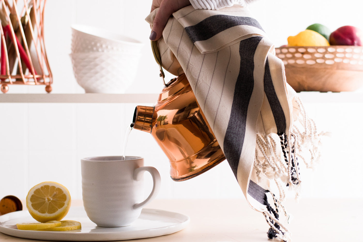 A natural cotton Turkish hand towel being used to pour water from a hot kettle