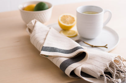 A natural cotton Turkish hand towel sitting next to a mug of lemon tea