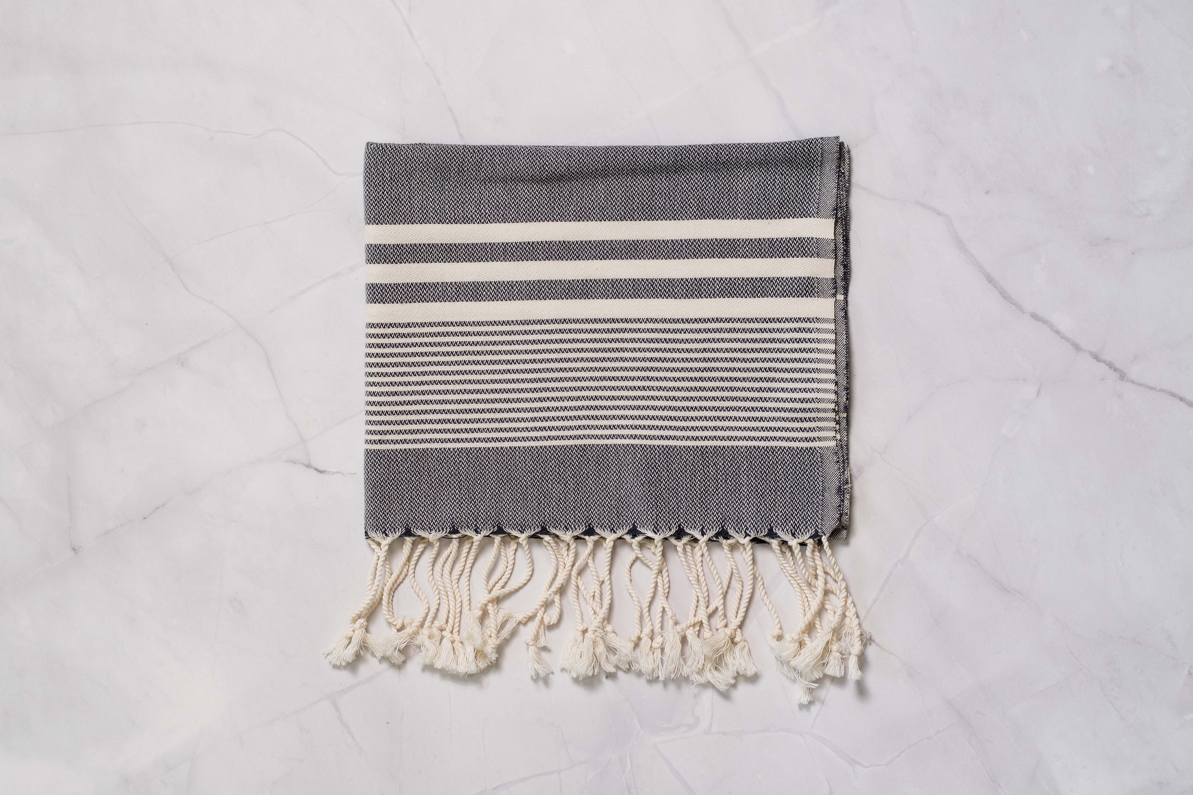 A charcoal grey lightweight Turkish hand towel