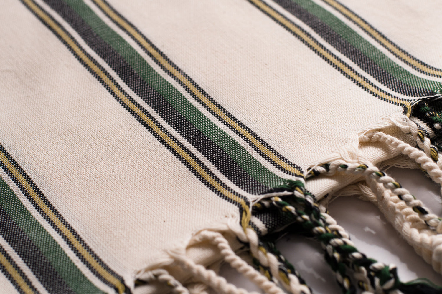 A close up of a white and green natural cotton Turkish hand towel showing texture