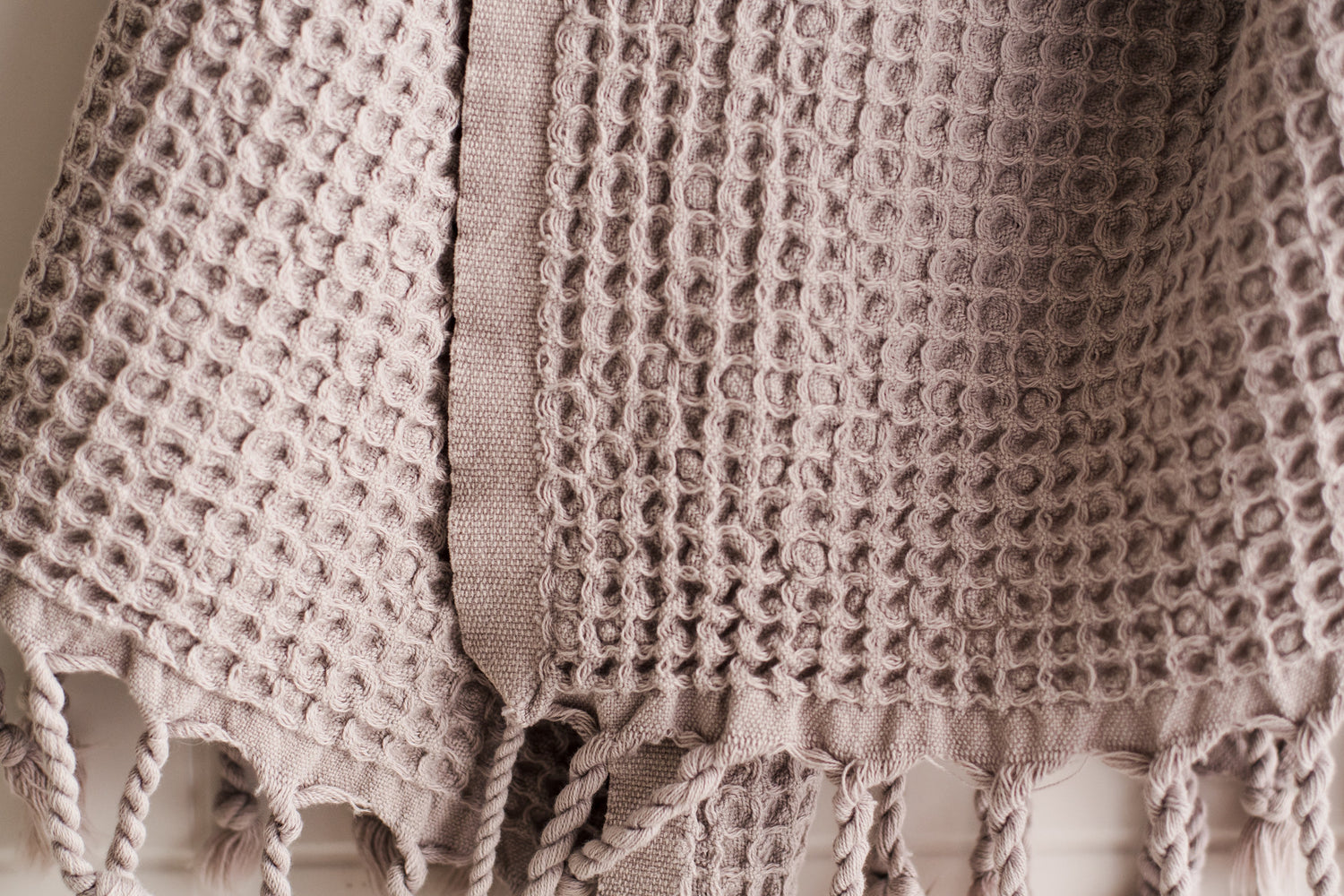 A close up showing the waffle texture of a natural cotton Turkish hand towel in beige