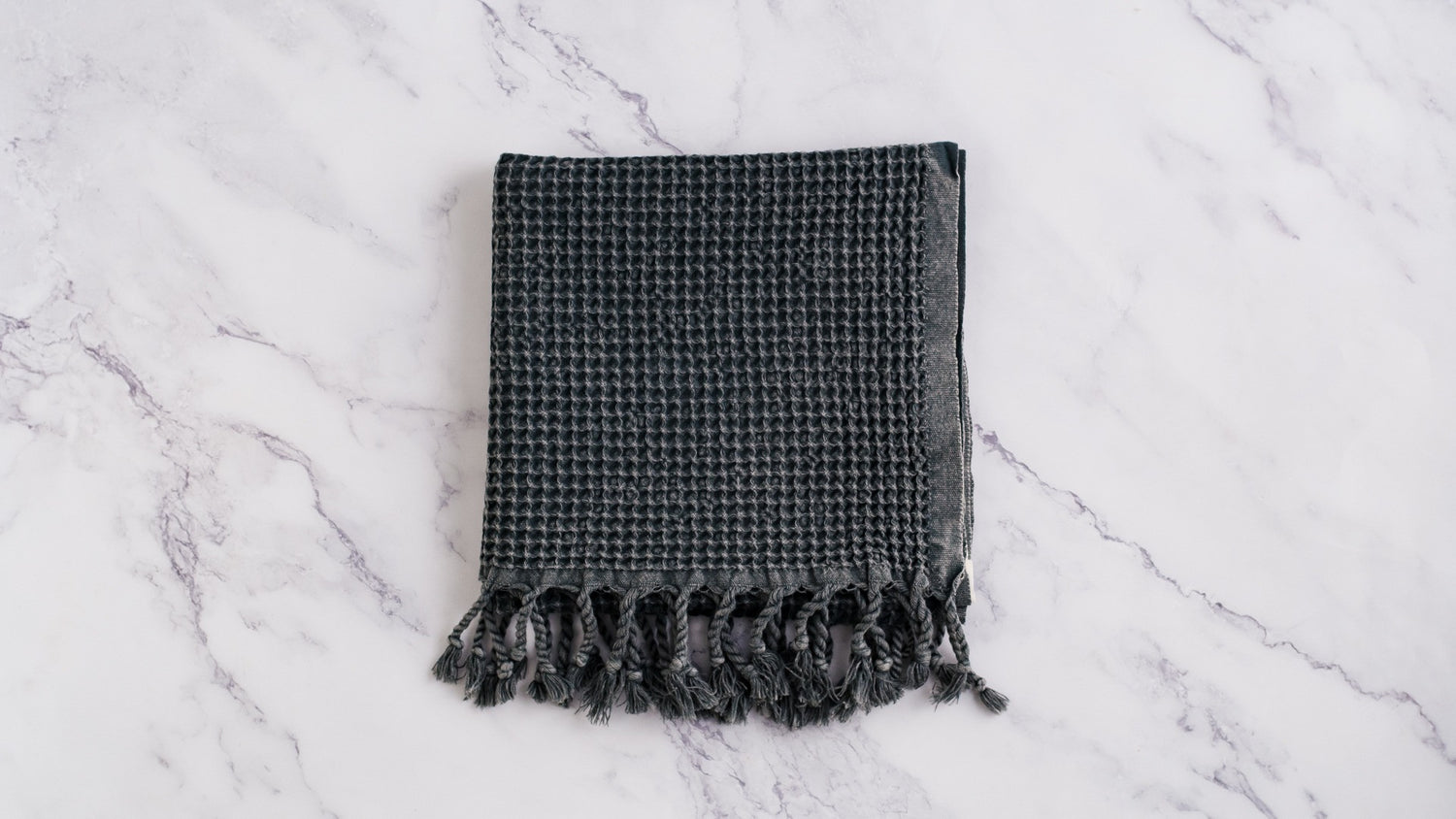 A waffle texture natural cotton Turkish hand towel in dark grey