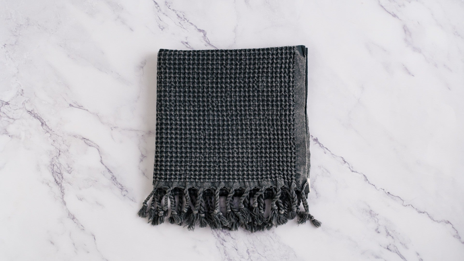 A waffle texture natural cotton Turkish hand towel in dark grey