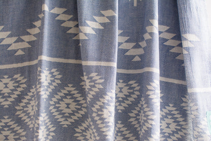 A close up of a medium weight Turkish bath towel in denim blue with geometric pattern showing texture