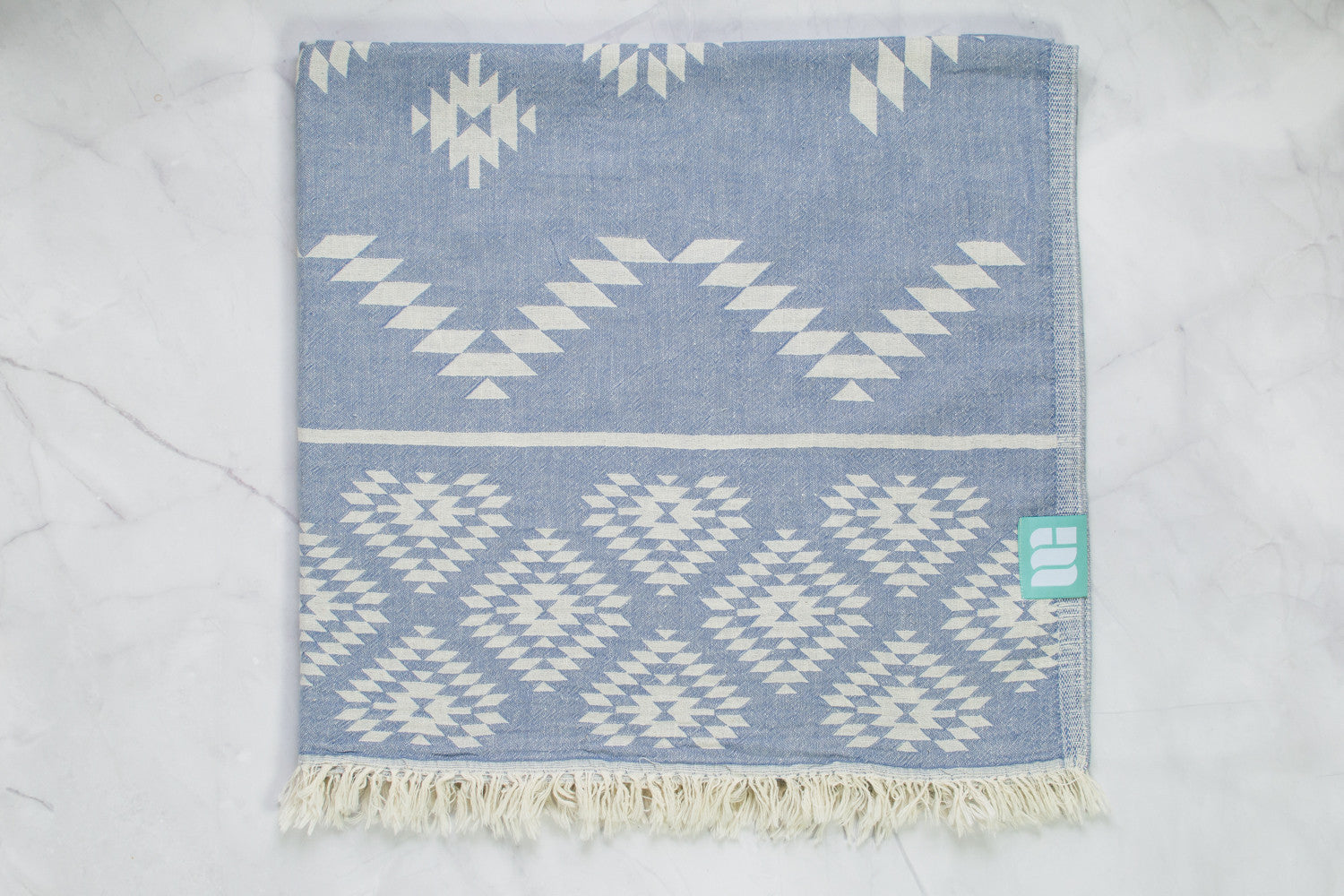 A medium weight Turkish bath towel in denim blue with geometric pattern