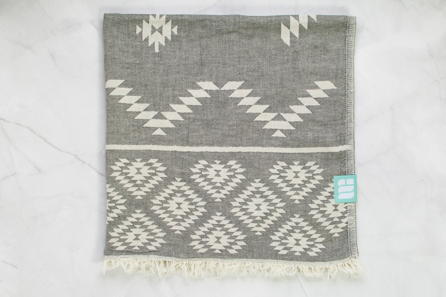 A medium weight Turkish bath towel in grey with geometric pattern