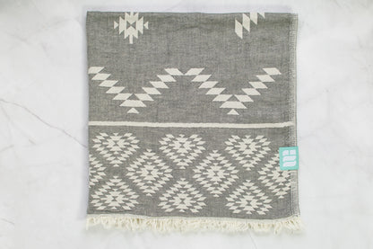 A medium weight Turkish bath towel in grey with geometric pattern