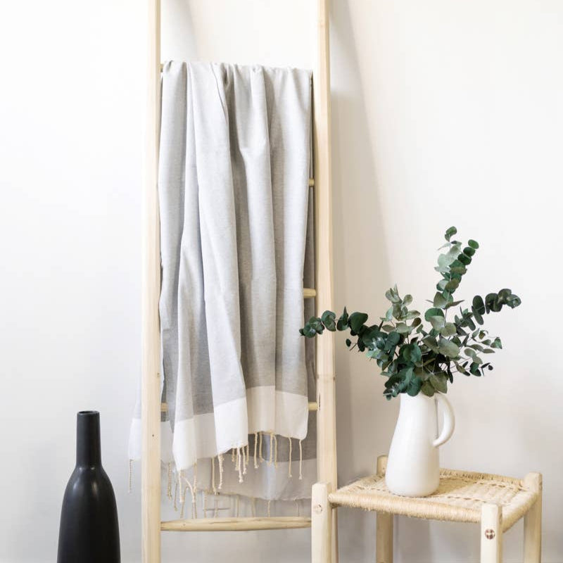 A light grey natural cotton Turkish towel hangs on a ladder