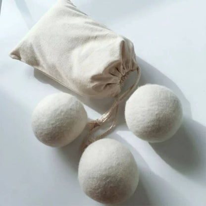 Three of six wool dryer balls with the other three in the included storage bag