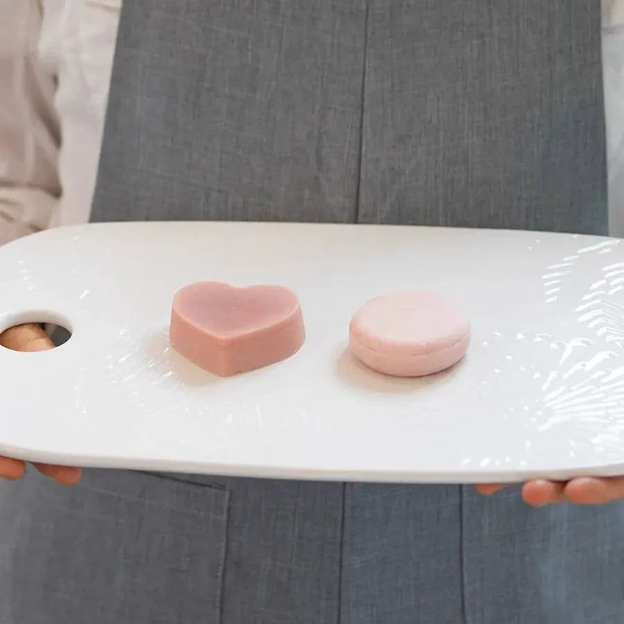 Eco-friendly nourishing shampoo and conditioner bar set on a tray