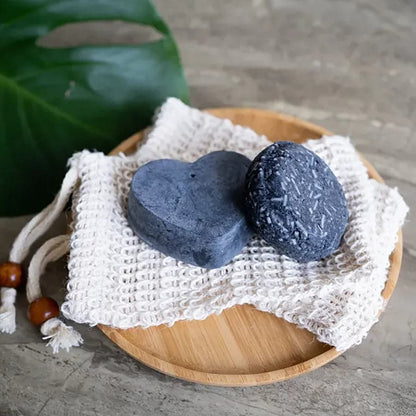 Rebalancing natural shampoo and conditioner bars sitting on a bamboo tray