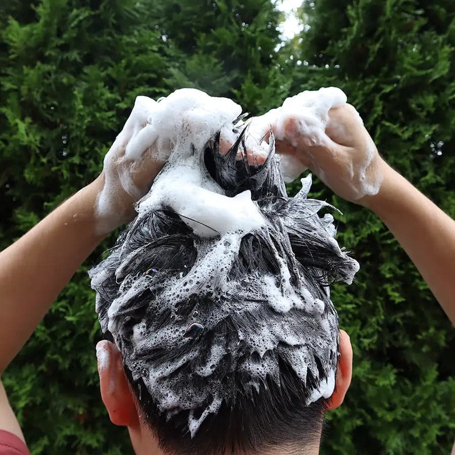 A person using natural shampoo bar