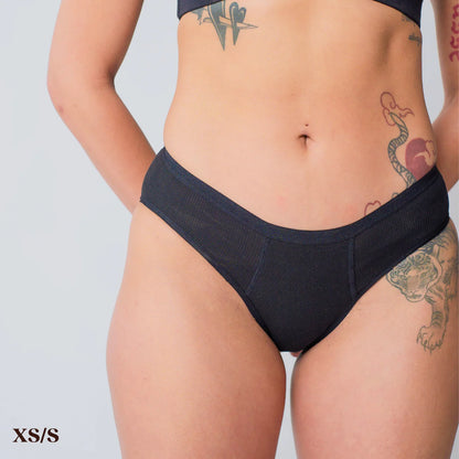 A person wearing REVOL bikini briefs in size x-small/small