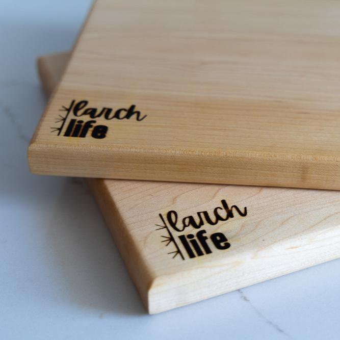 A close up showing the logos and grain on two solid hard wood cutting boards