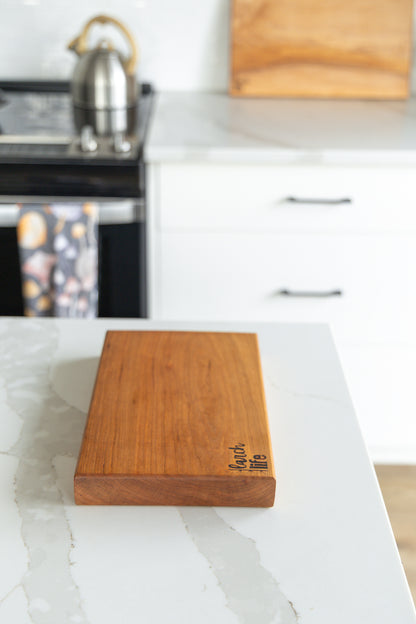 Wooden cutting board on a kitchen counter with blurred background