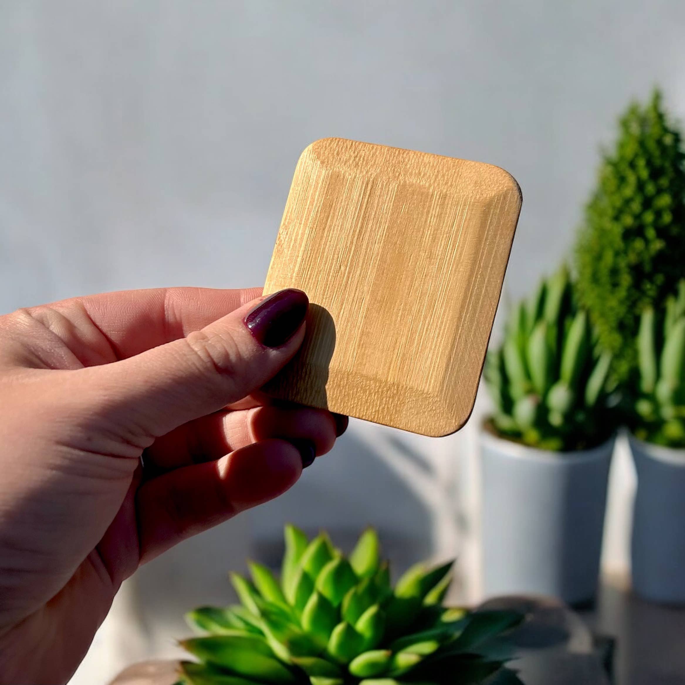 A person holds a sustainable bamboo pot scraper