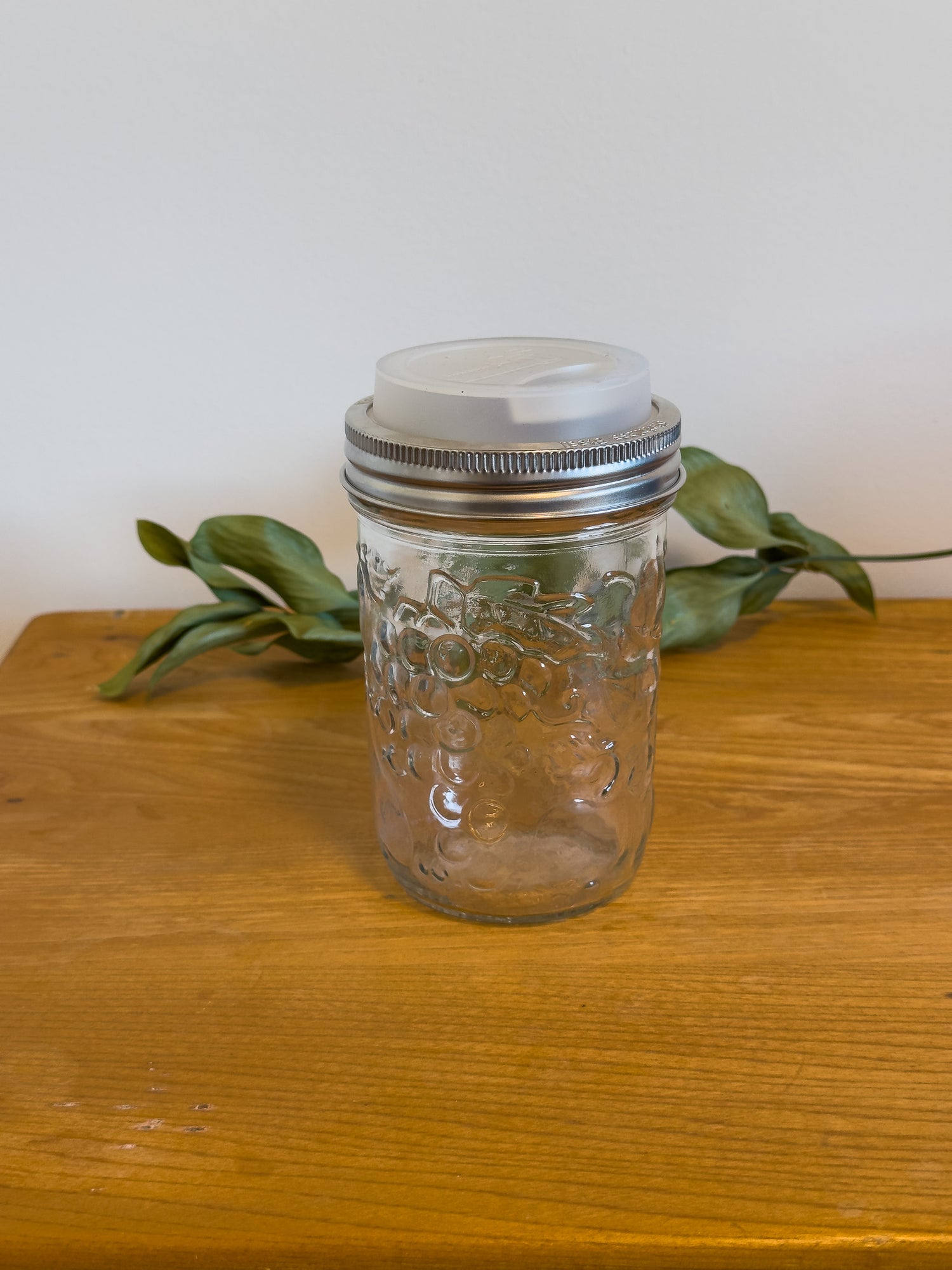 A wide-mouth mason jar with sustainable silicone travel lid