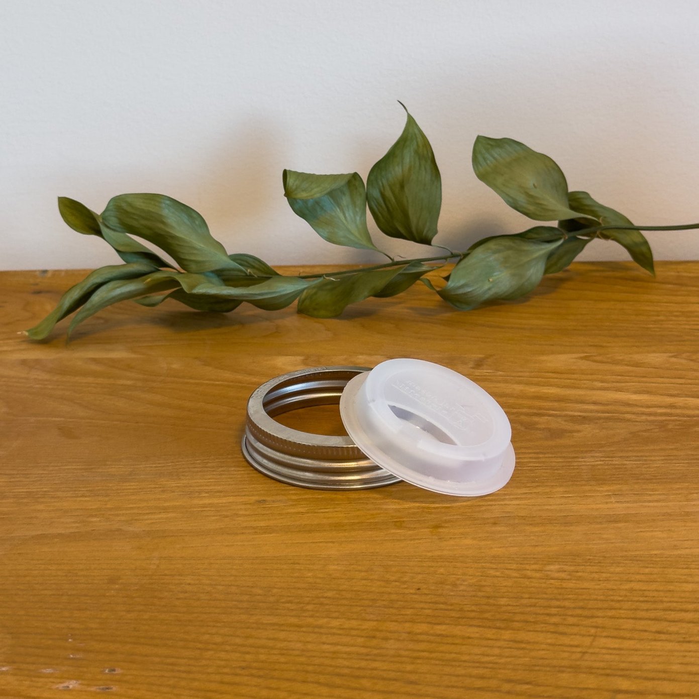 A sustainable silicone travel lid for a standard or narrow-mouth mason jar