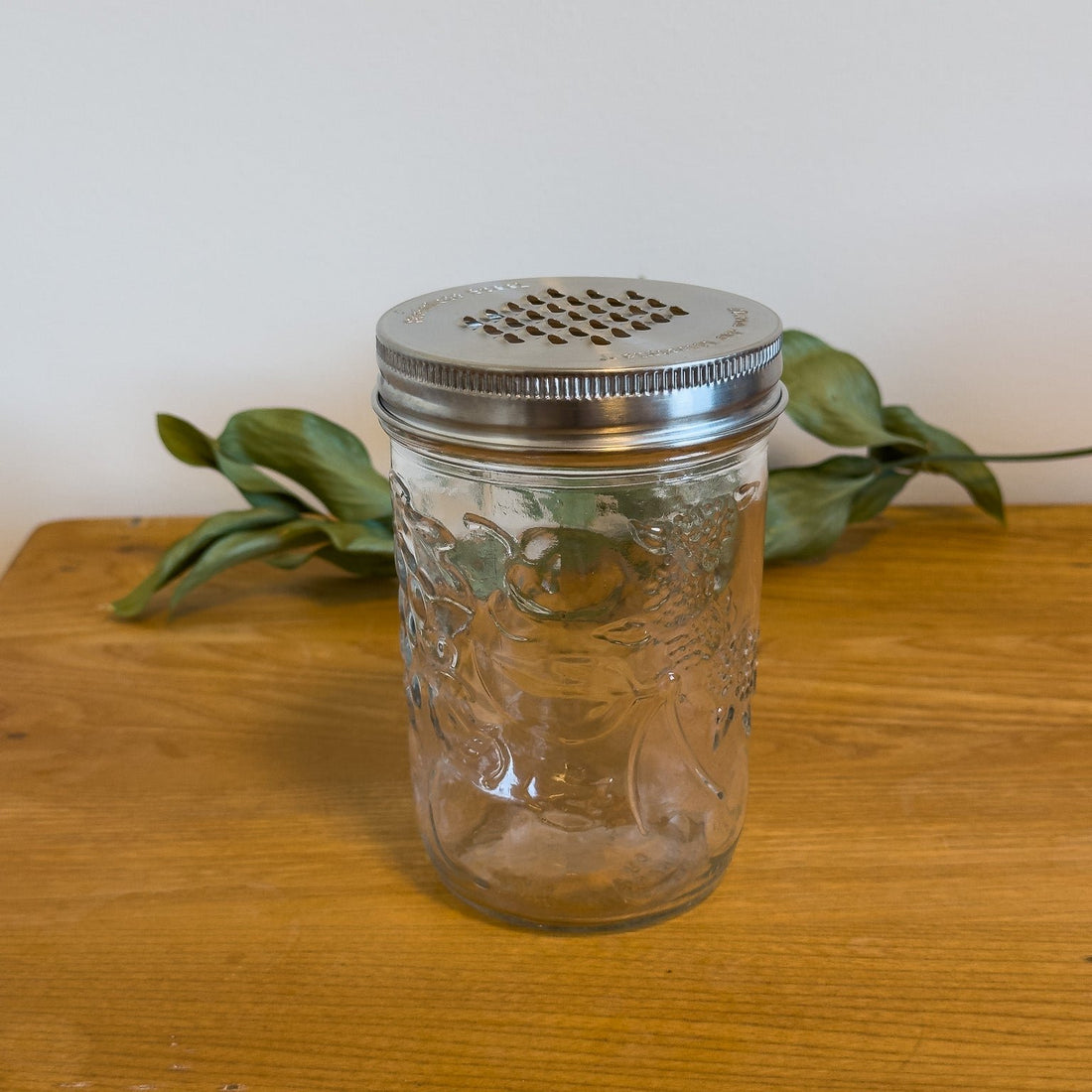 A stainless steel grater lid on a wide-mouth mason jar