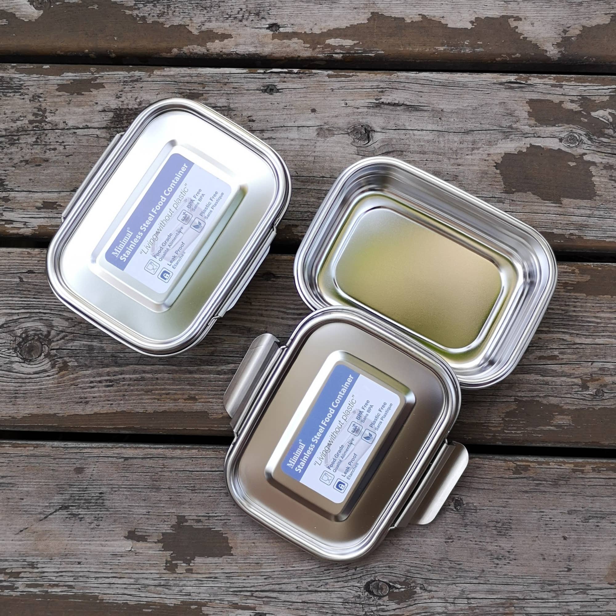 Two medium size stainless steel bento boxes shown from above, one with lid on and the other with lid off