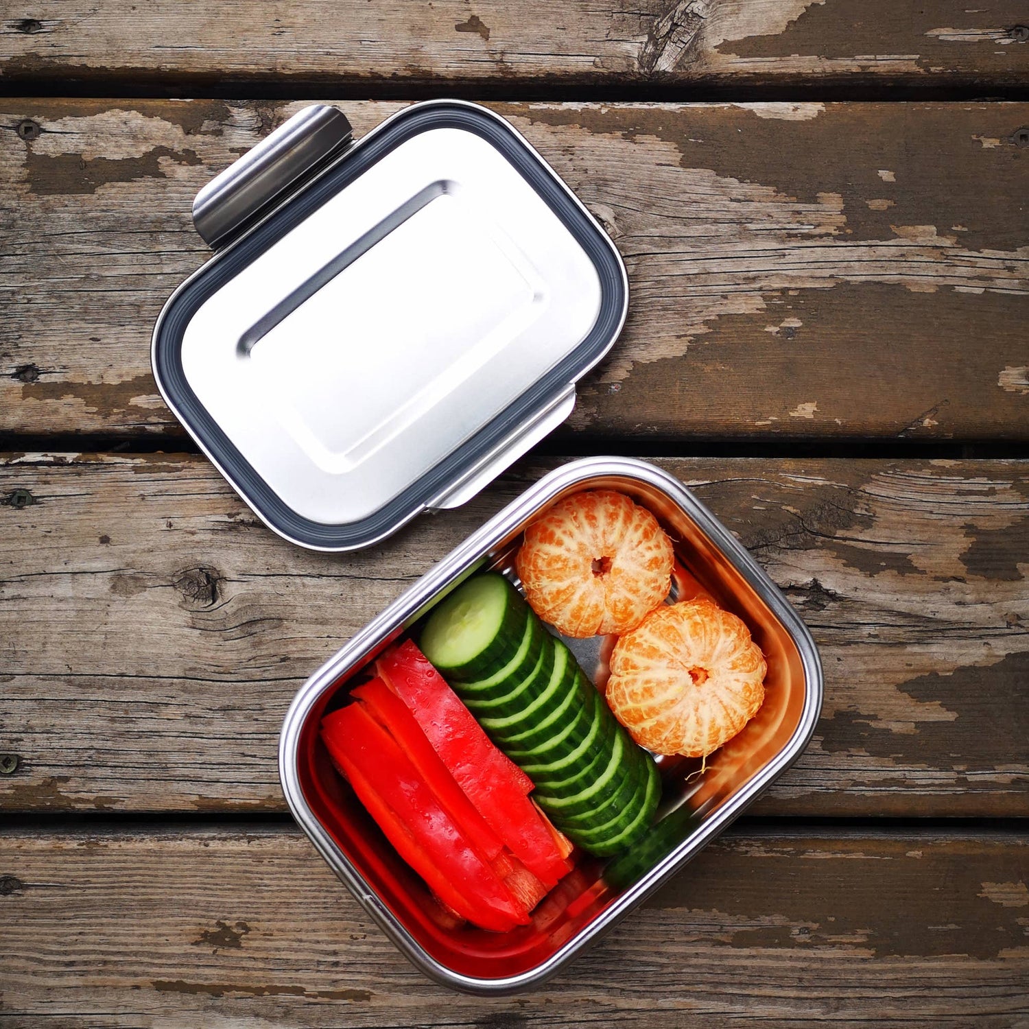 A stainless steel bento box holding a variety of produce